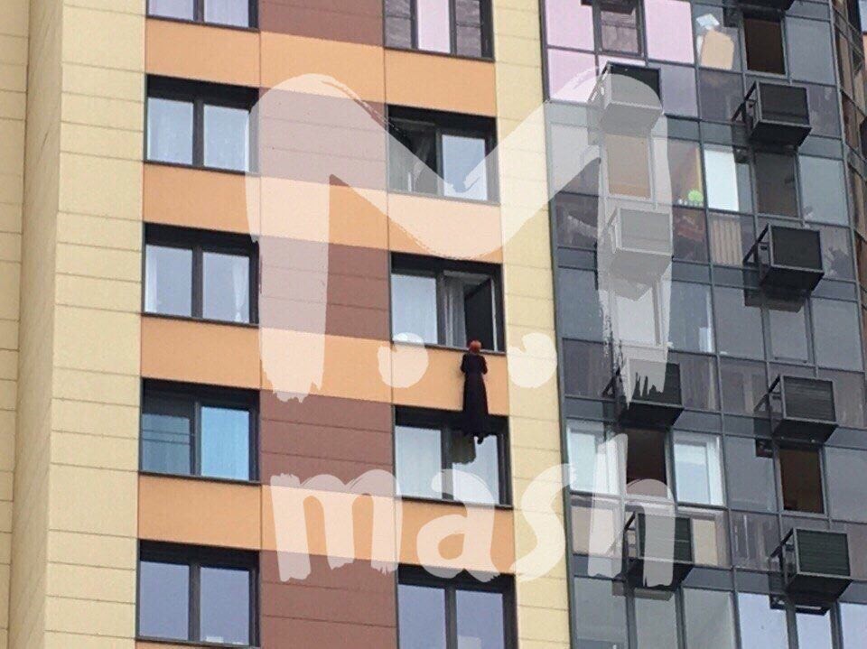 В Новой Москве девушка висит на фасаде дома на глазах у прохожих